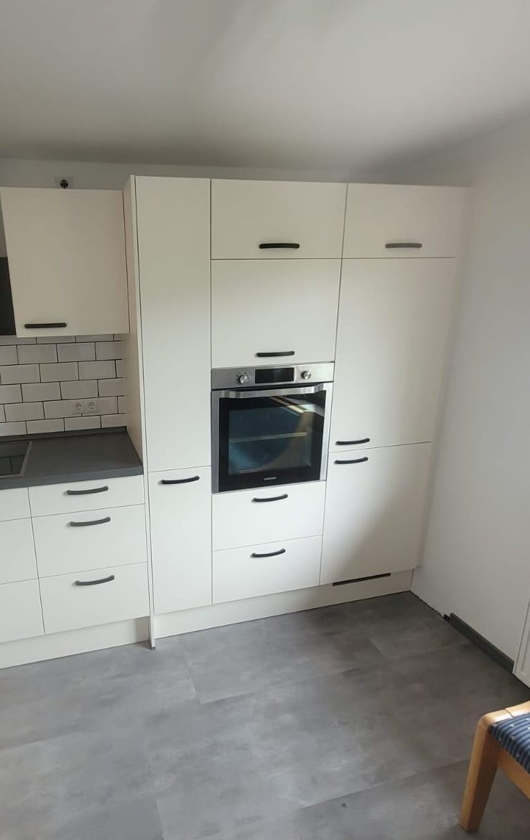 Hochschränke in einer weißen Küchenzeile mit hochgebautem Backofen
