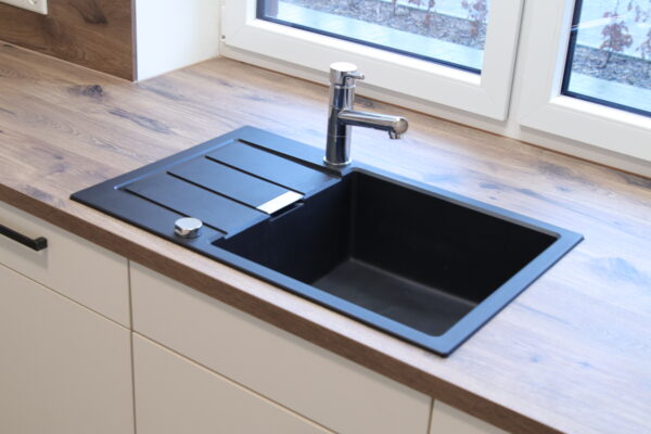 Detailansicht dunkle Spüle mit Ablage